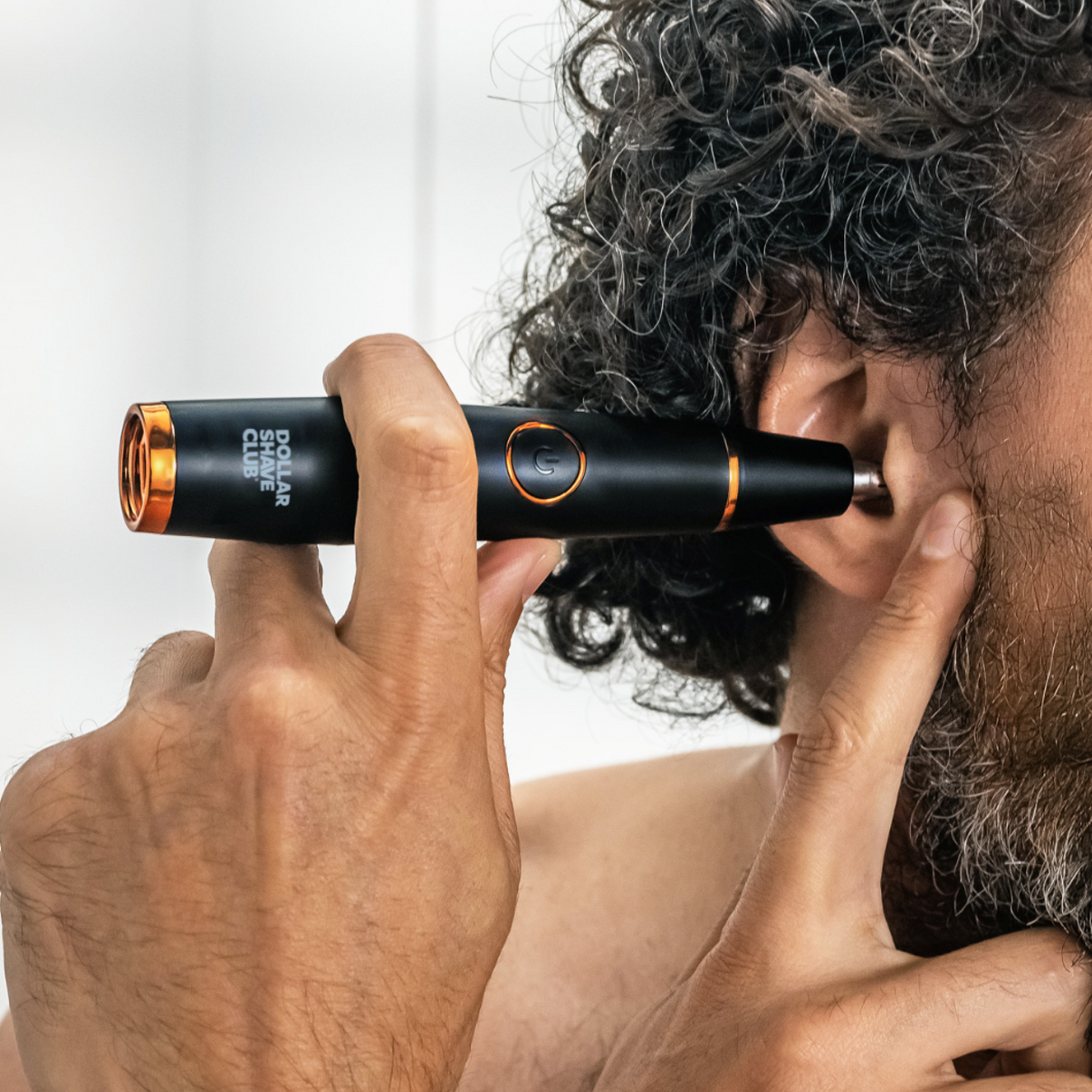 Man using rotary head of Style Detailer to trim unwanted ear hair