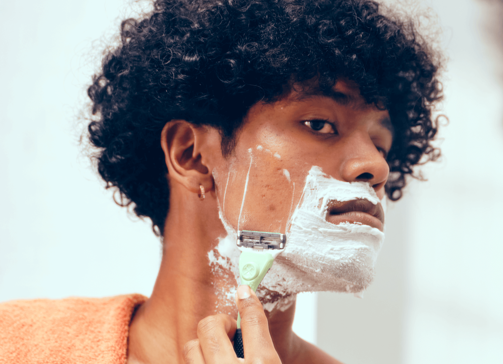 Man shaving with acne.