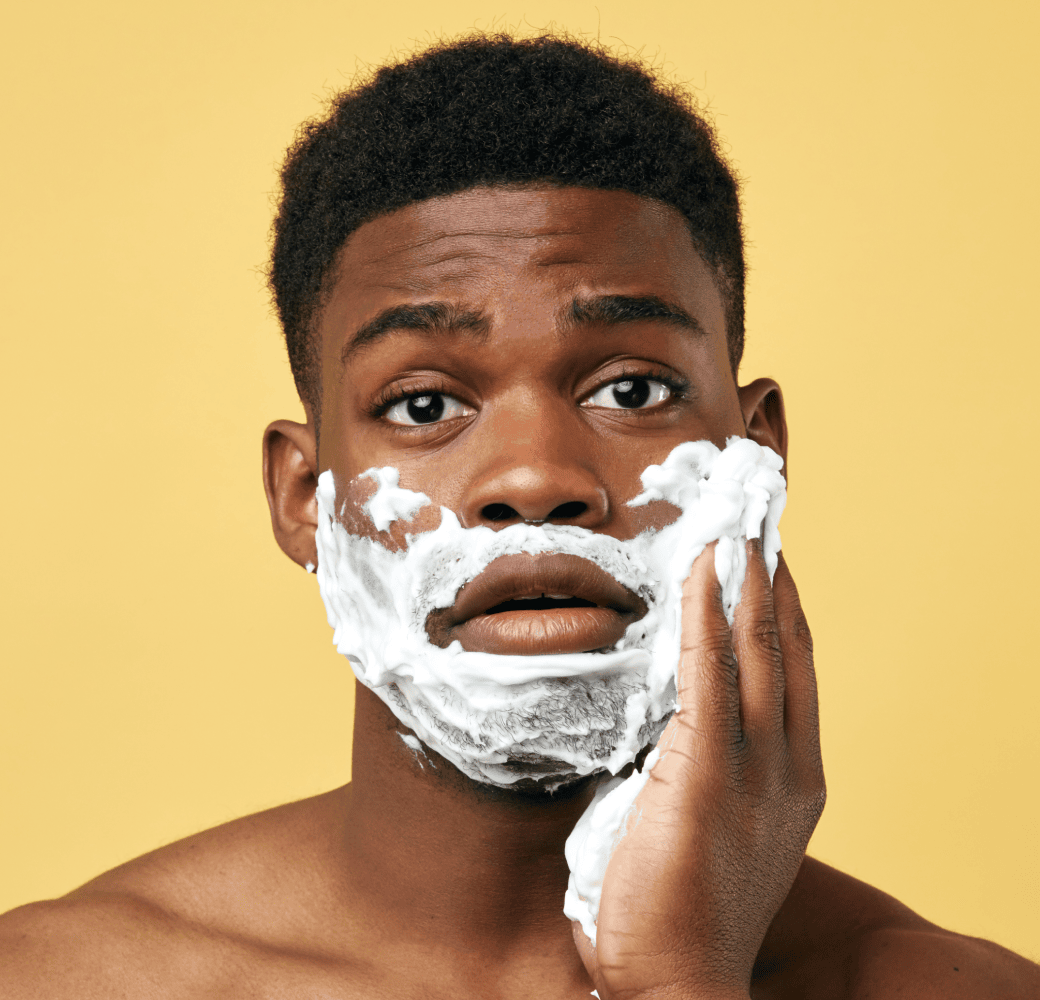 Man lathering shaving cream onto his face.