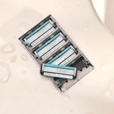 pack of four 4-blade razor cartridges on surface with moisture beadlets