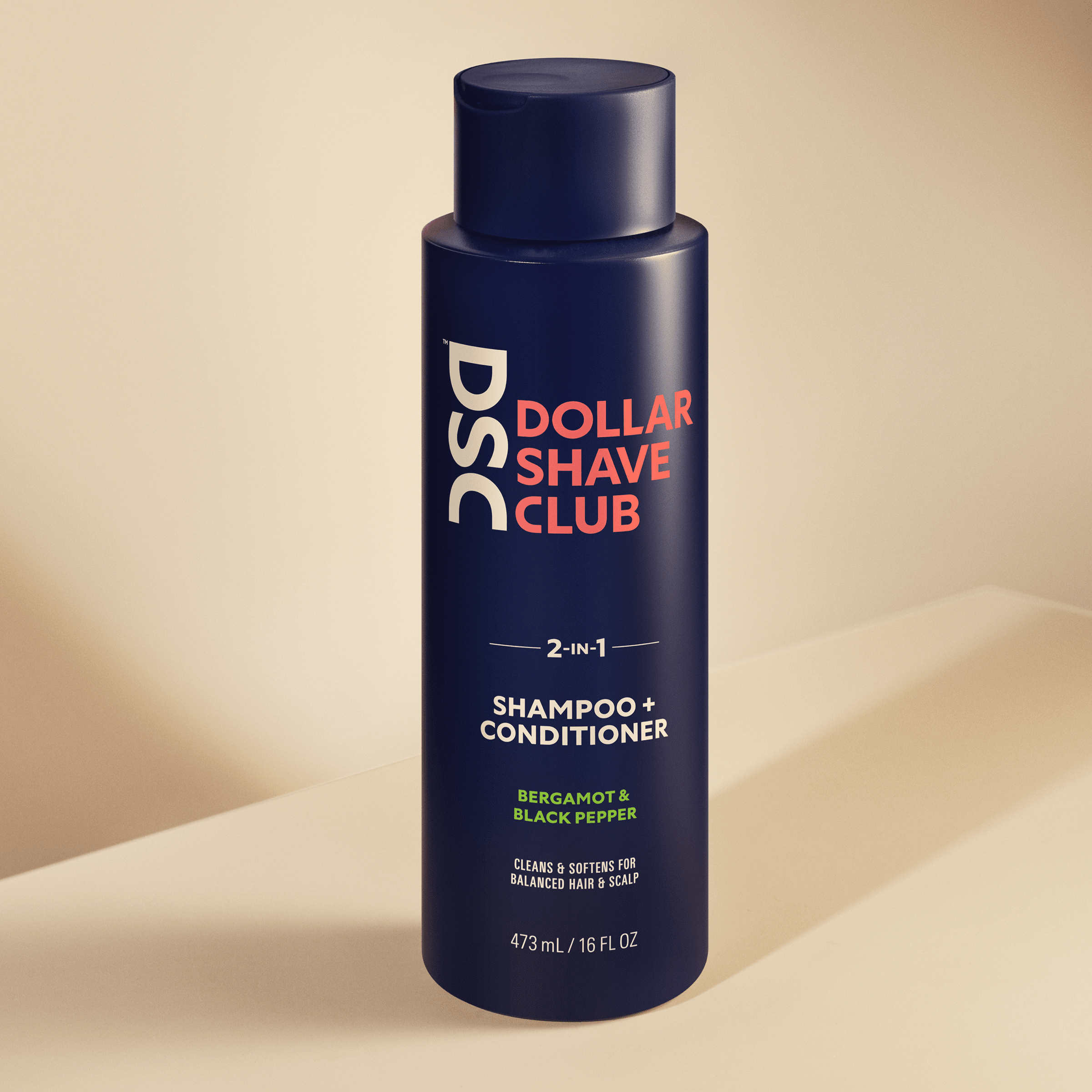 Dollar Shave Club Shampoo and Conditioner Bergamot Black Pepper against tan backdrop.