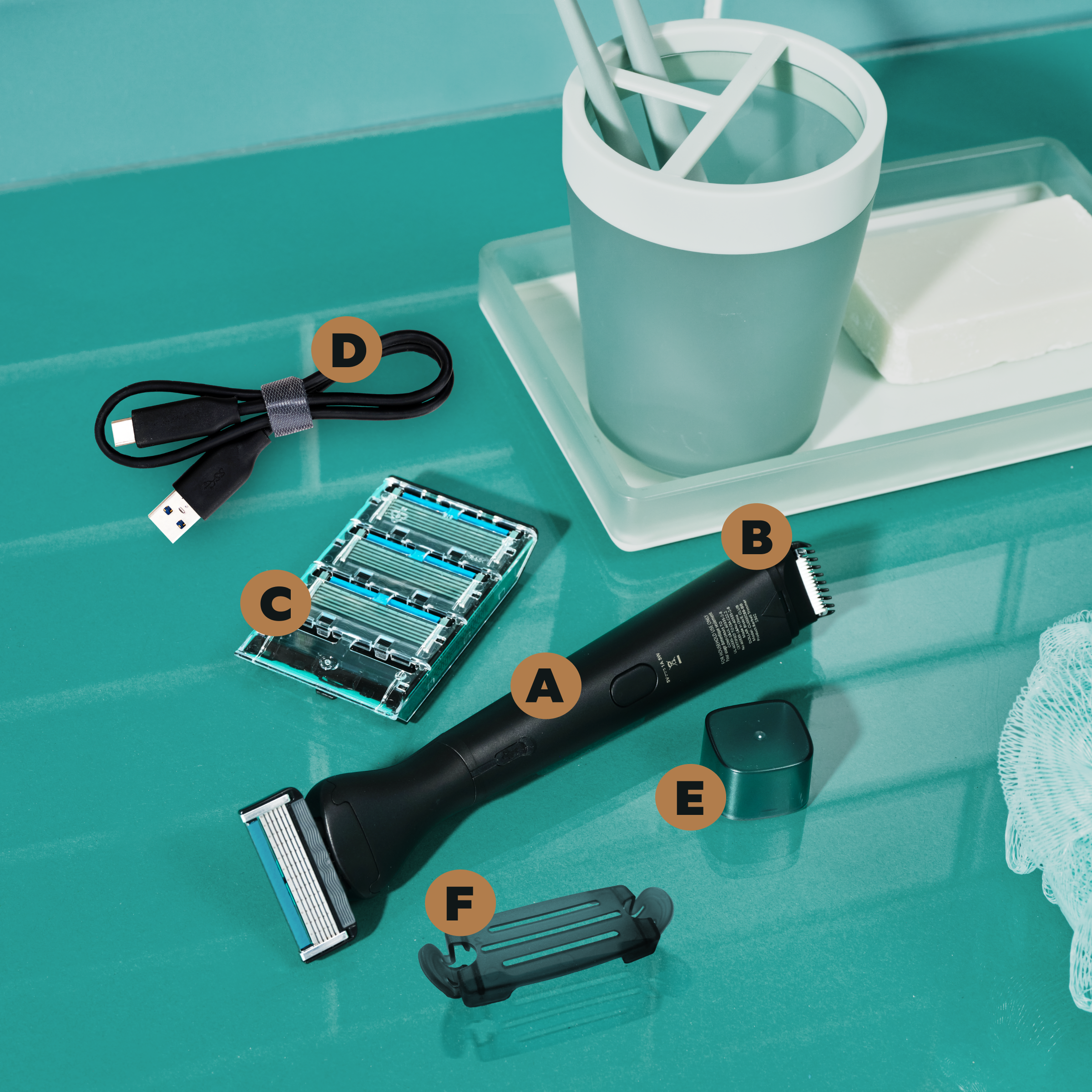 3-in-1 Freestyler Electric Trimmer/Razor, razor heads, a charging cord, and covers on an aquamarine bathroom counter. 