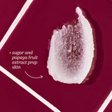 Close-up of a sugar scrub with papaya fruit extract on a red background
