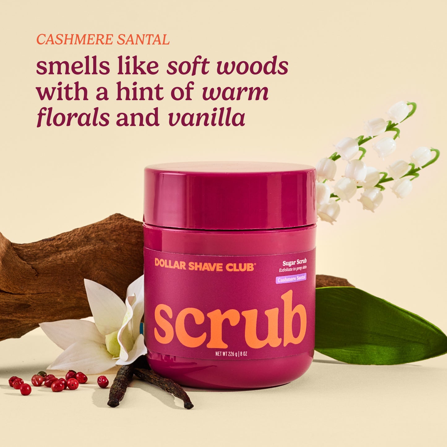 Dollar Shave Club scrub jar with floral and wood elements on a beige background