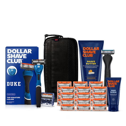 Dollar Shave Club Duke University grooming kit on a white background. Includes a blue razor handle with the Duke Blue Devils logo, 24 blades, Shave Butter, Prep Scrub, a black 3-in-1 electric trimmer, and a black traveler case.