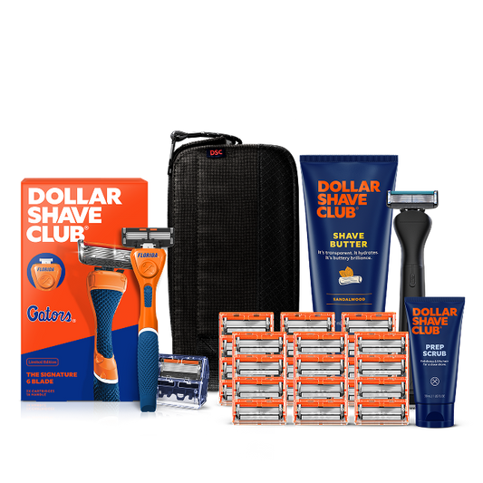 Dollar Shave Club University of Florida grooming kit on a white background. Includes a blue razor handle with the Florida logo, 24 blades, Shave Butter, Prep Scrub, a black 3-in-1 electric trimmer, and a black traveler case.