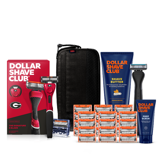 Dollar Shave Club University of Georgia grooming kit on a white background. Includes a red razor handle with the Georgia Bulldogs "G" logo, 24 blades, Shave Butter, Prep Scrub, a black 3-in-1 electric trimmer, and a black traveler case.