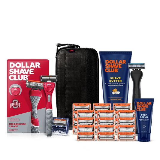 Dollar Shave Club Ohio State University grooming kit on a white background. Includes a scarlet razor handle with the OSU Buckeyes logo, 24 blades, Shave Butter, Prep Scrub, a black 3-in-1 electric trimmer, and a black traveler case.