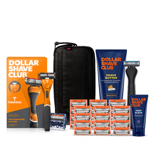 Dollar Shave Club University of Tennessee grooming kit on a white background. Includes an orange razor handle with the Tennessee Volunteers "T" logo, 24 blades, Shave Butter, Prep Scrub, a black 3-in-1 electric trimmer, and a black traveler case.