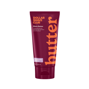 Dollar Shave Club shave butter tube with maroon and orange design on a white background