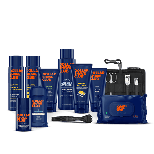 Collection of Dollar Shave Club products including bottles, a pouch, and grooming tools on a black background.
