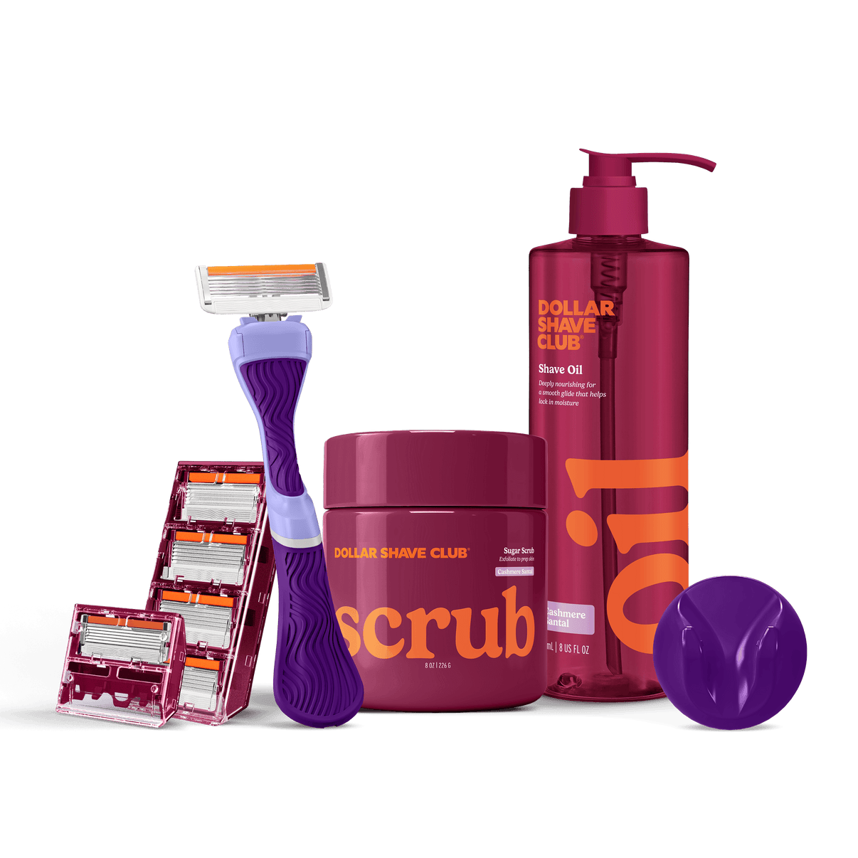 Dollar Shave Club grooming products including a razor, scrub, and shave oil on a black background.