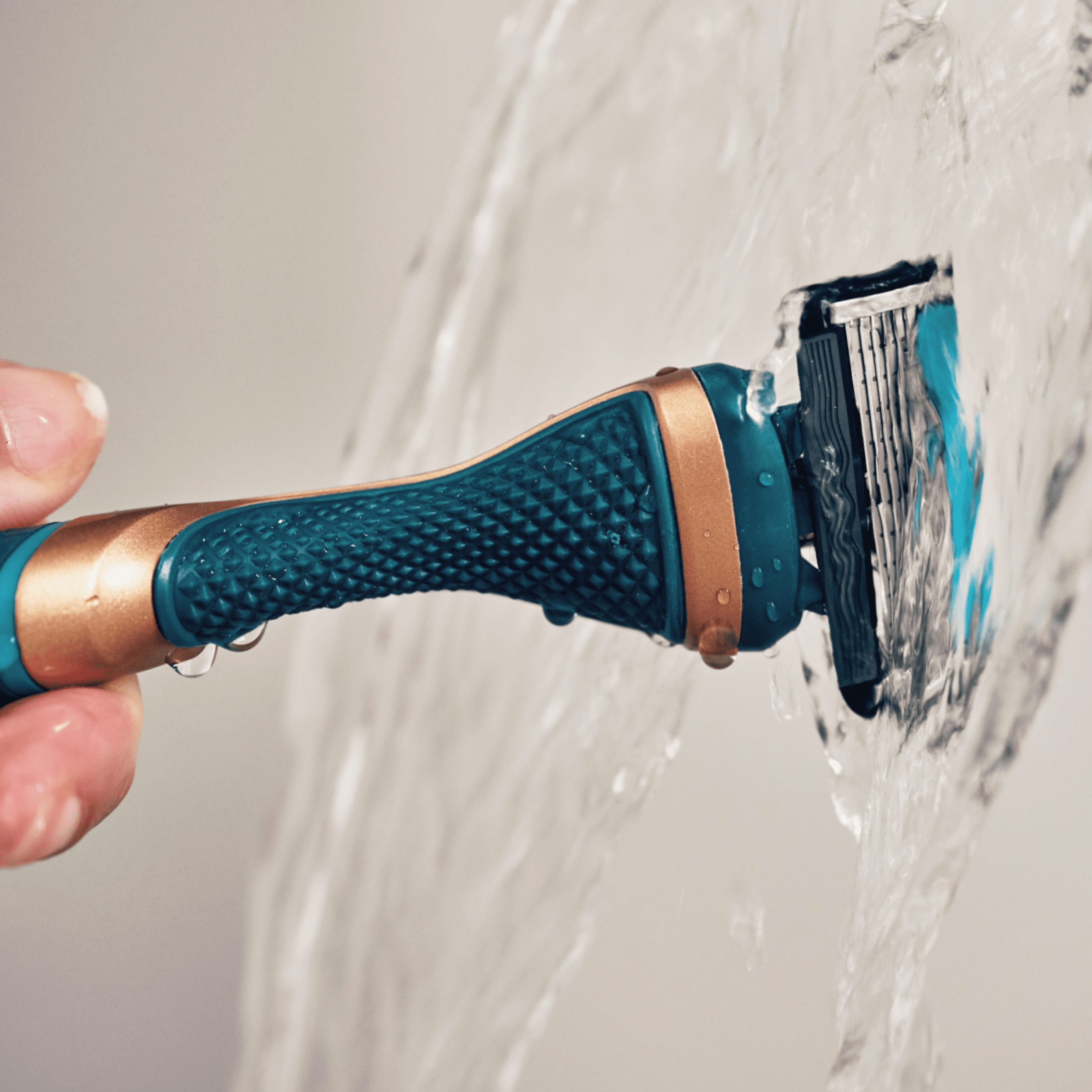 Dollar Shave Club body Shaver Handle shown being used running under water.