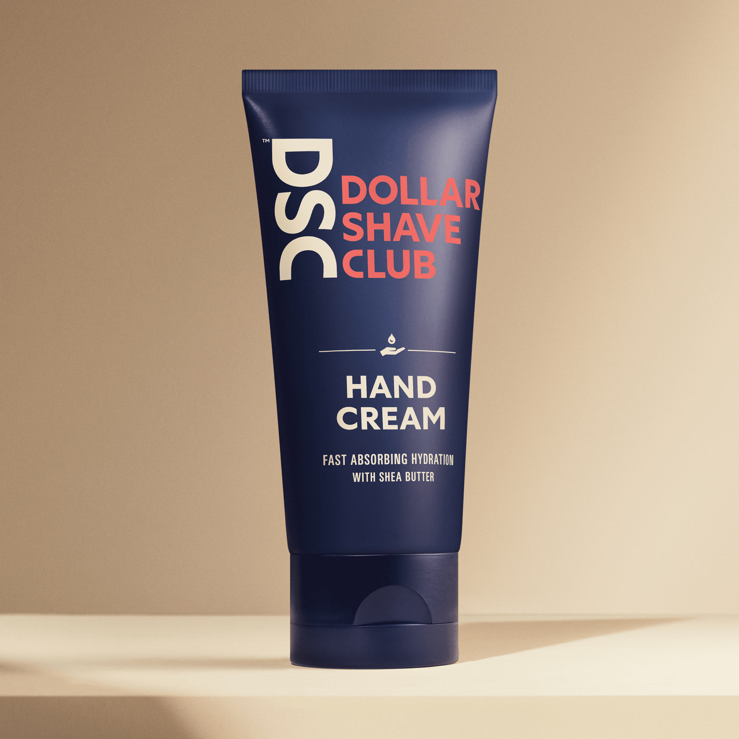 Dollar Shave Club Hand Cream against tan backdrop.