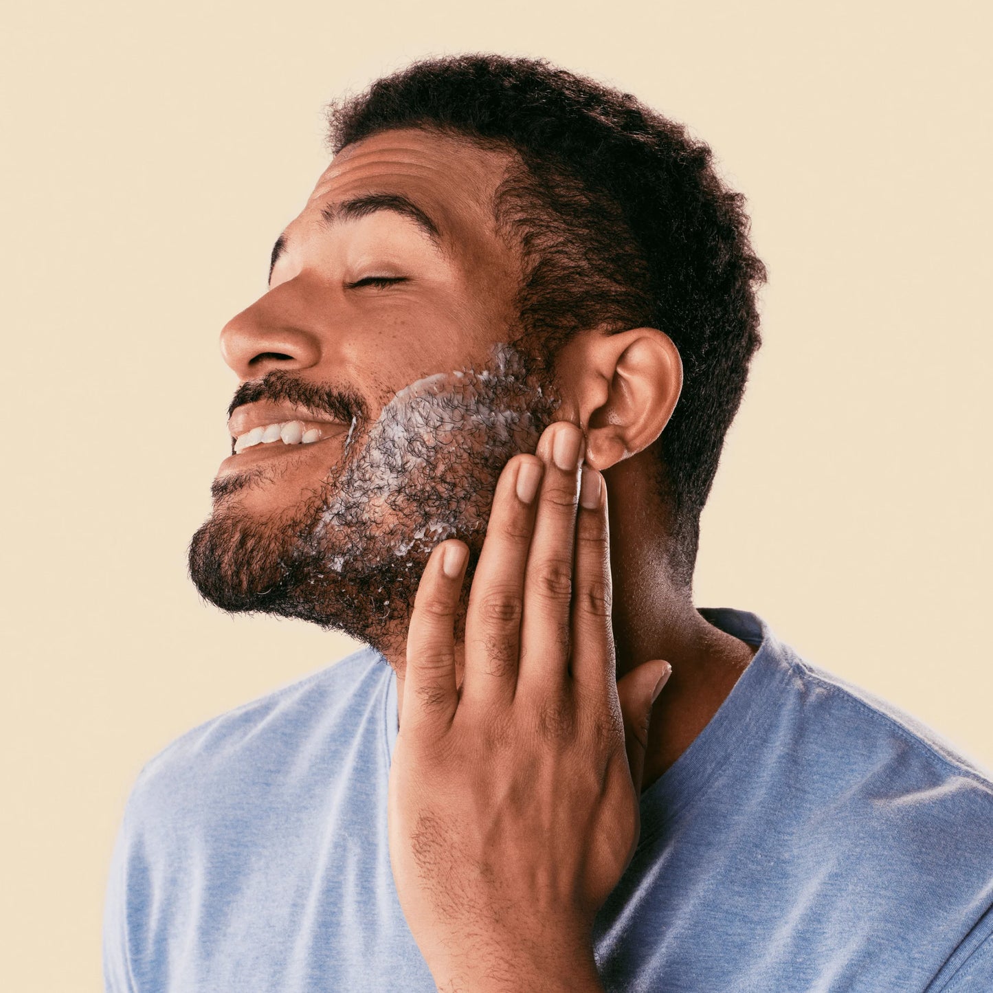 man applying shave butter to beard