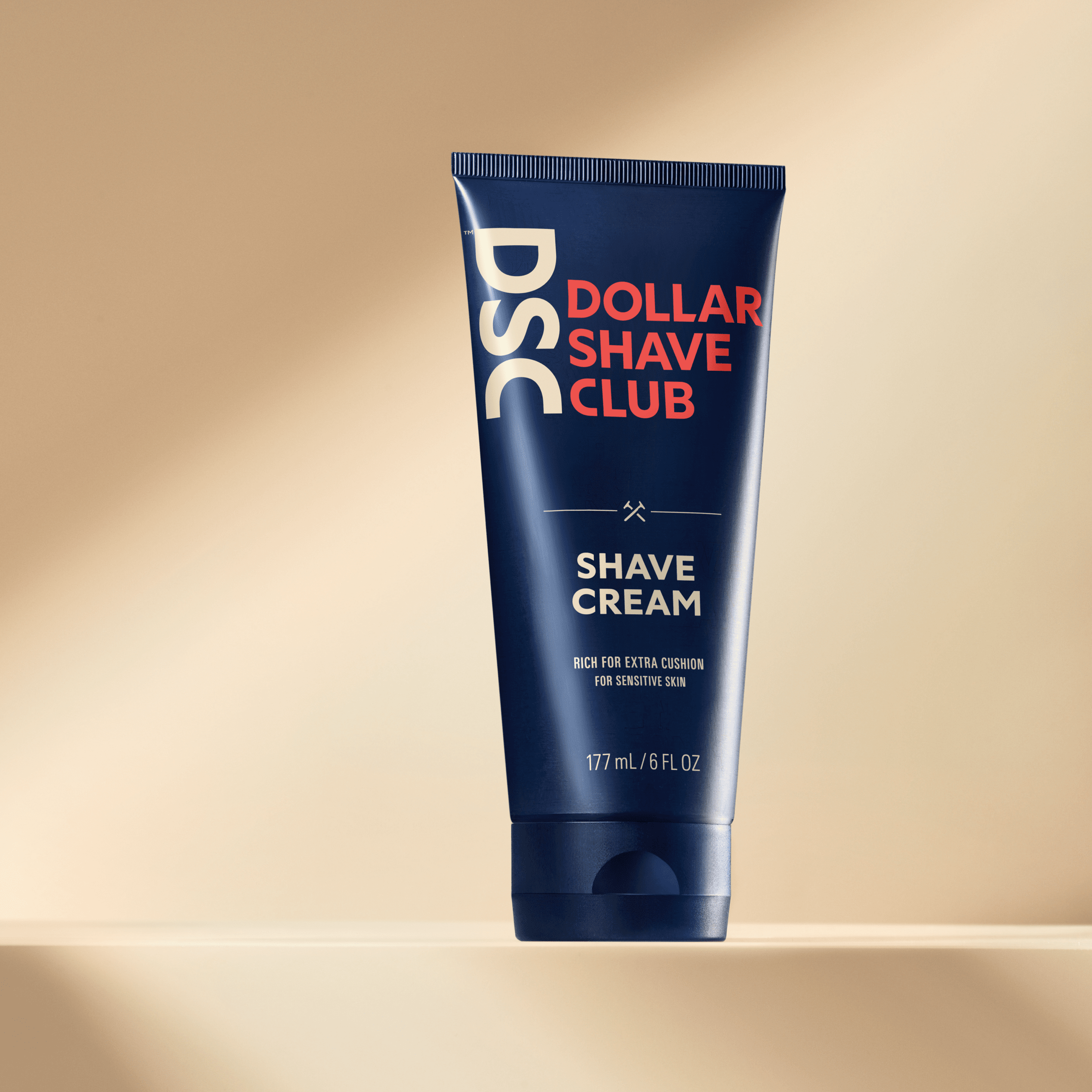 Dollar Shave Club Shave Cream product image against tan backdrop.