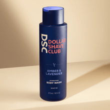 Dollar Shave Club Whole Body Wash Amber Lavender against tan backdrop.