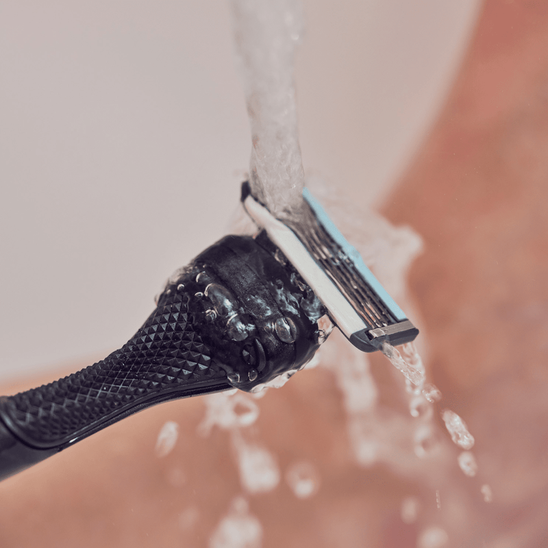 Razor being washed under water.