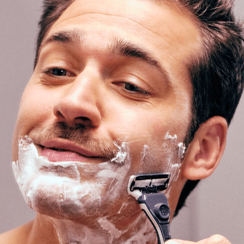 man finishing up shaving his beard